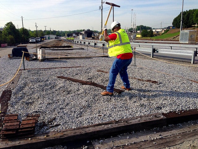 A Railinc employee drives a rail spike in the yard at CSX REDI.